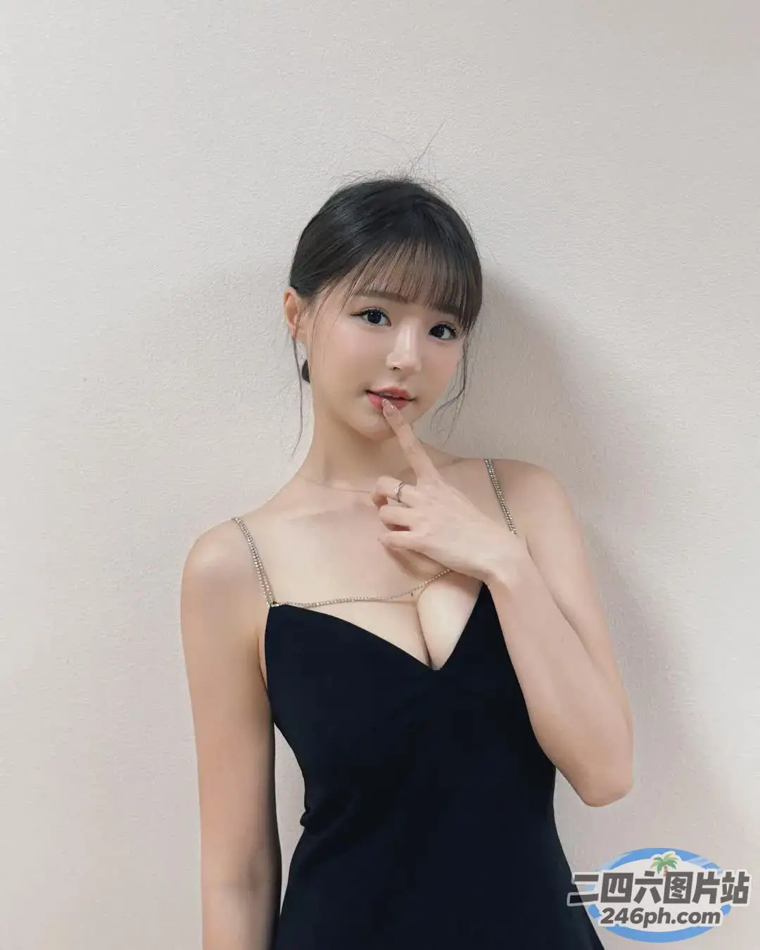 一位身穿黑色连衣裙的女子摆姿势拍照的特写