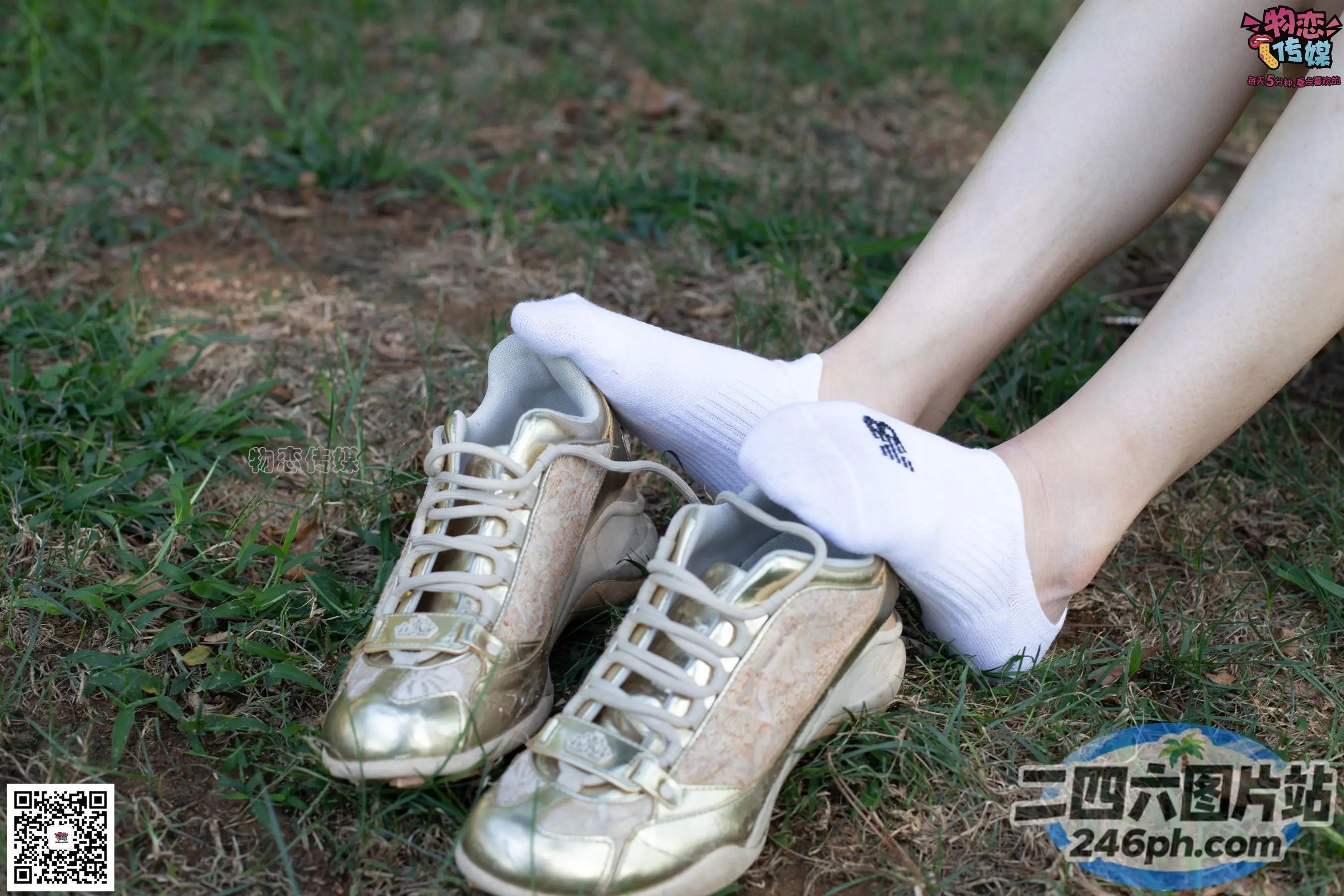 有人坐在一双金鞋和白袜子上