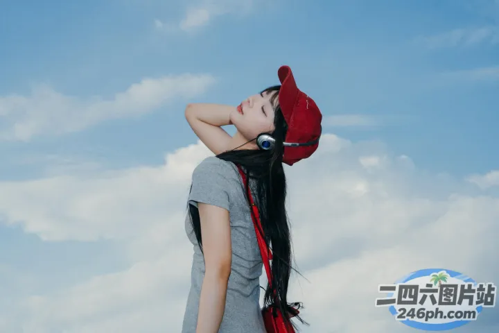 广告牌前站着一个戴着耳机的女人