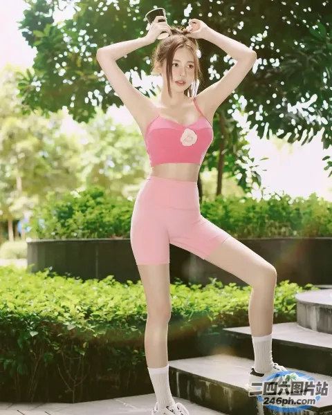 一名身穿粉红色运动服的女子在公园的台阶上摆姿势
