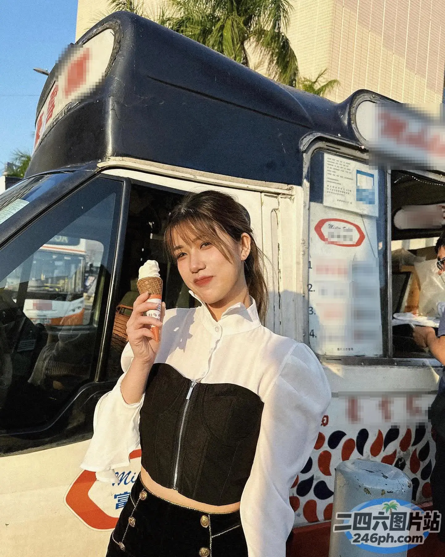 身穿黑白服装的女子拿着一个冰淇淋甜筒