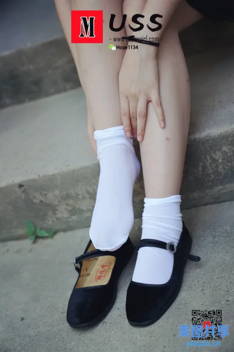 台阶上坐着一个女人，双脚抬起