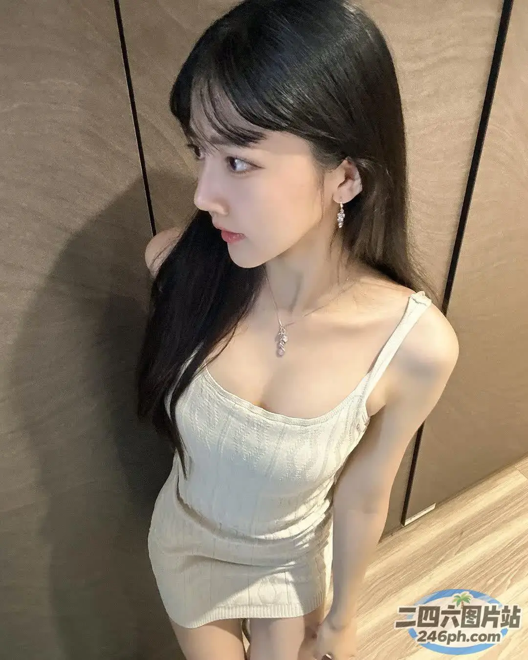 一位身穿白色连衣裙的女子摆姿势拍照的特写