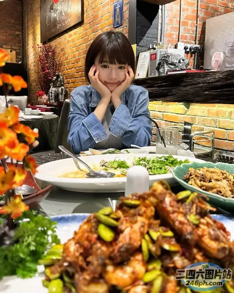有个女人坐在一张桌子旁，桌上放着一盘食物