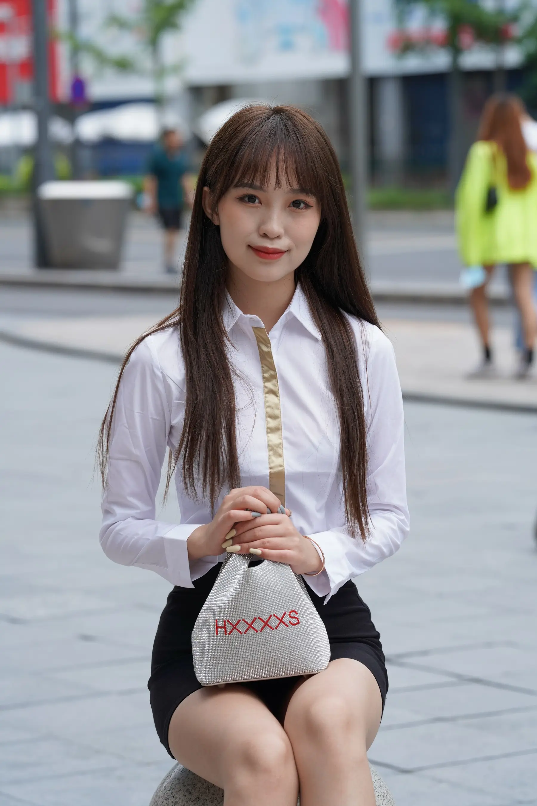 阿拉菲女人坐在岩石上，手里拿着一个袋子