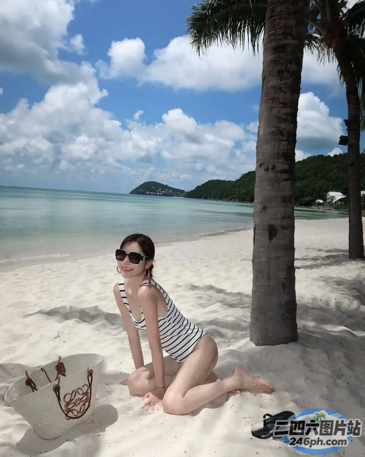 海滩上坐着一个戴着帽子和墨镜的女人