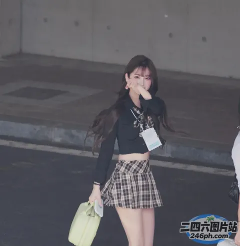 穿着裙子和黑色上衣的 araffe 女孩走在街上
