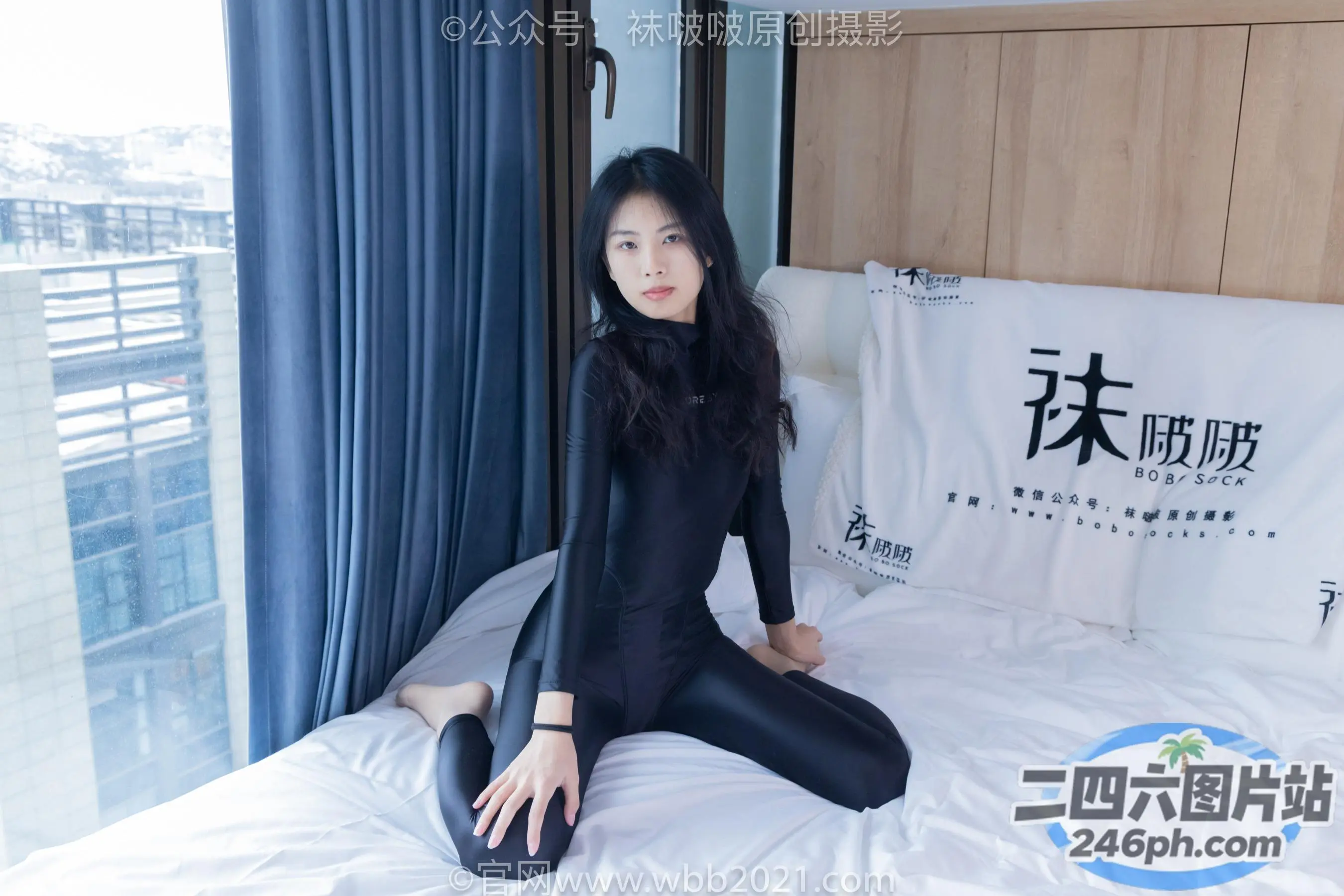 床上坐着一个穿着黑色衣服的女人