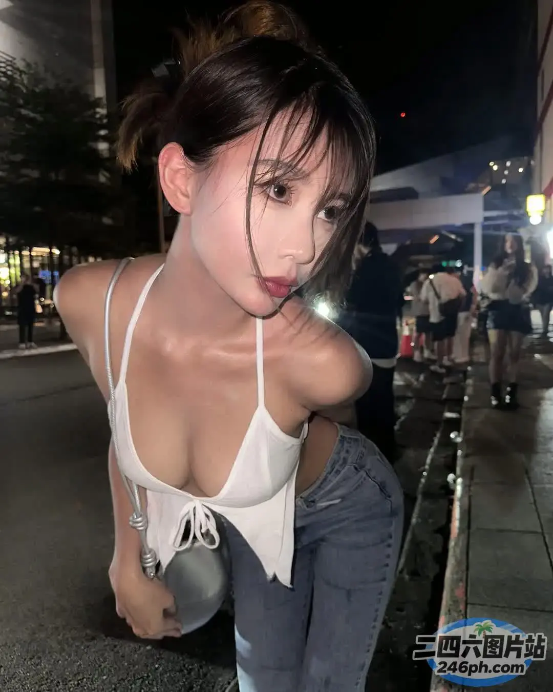 街头穿着白色上衣和牛仔裤的 Araffed 亚洲女人