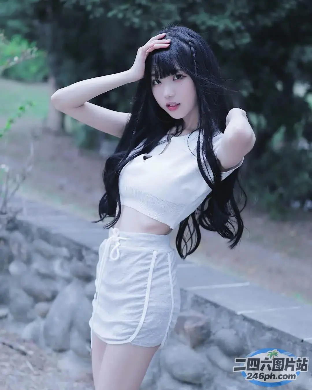一名身穿白色上衣和裙子的女子摆姿势拍照