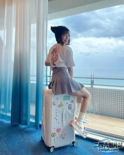 有一个女孩坐在一个手提箱上，手里拿着一个手提包