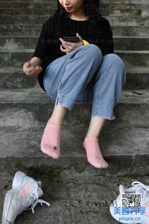 坐在台阶上用手机的 Araffe 女孩