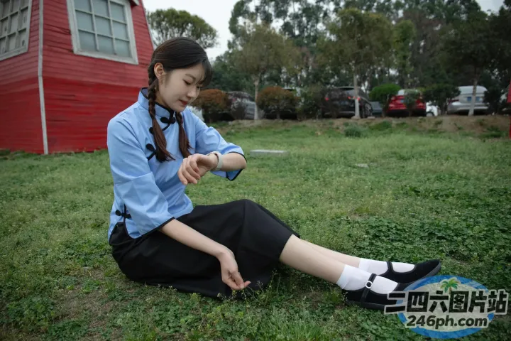 有个女人坐在草地上，手里拿着一本书