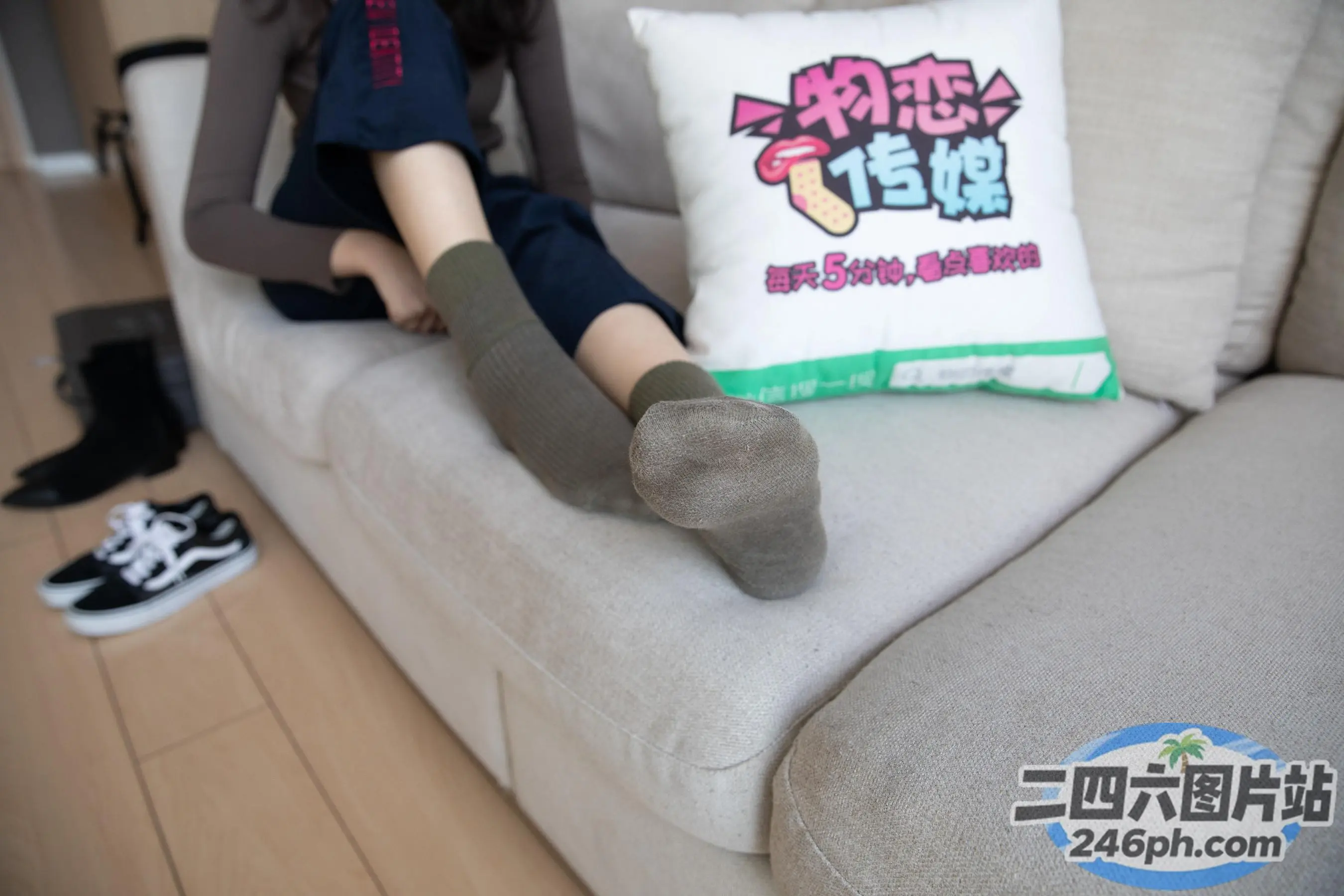 Araffe 坐在沙发上，手里拿着一个枕头和一双袜子