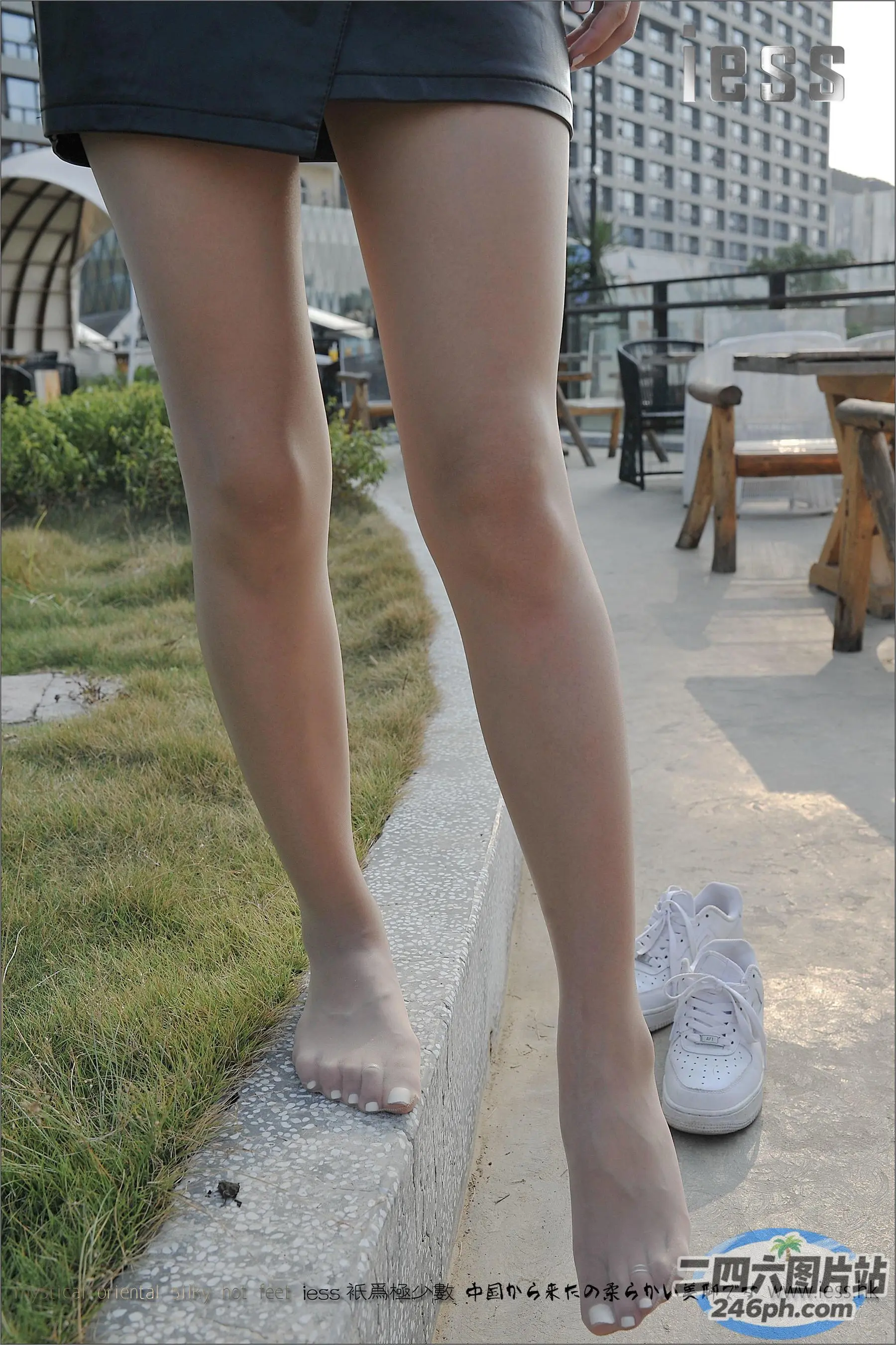 有个女人站在水泥块上，脚踩着鞋子