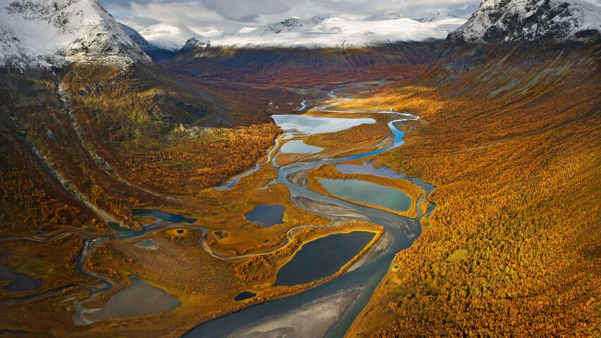 一条河流流经山谷的 arafed 视图，背景是群山