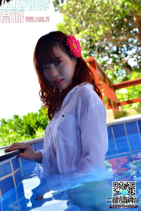 一个女人在游泳池里拿着笔记本电脑的特写