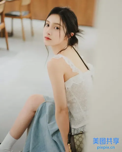 一个女人拿着钱包坐在地板上的特写