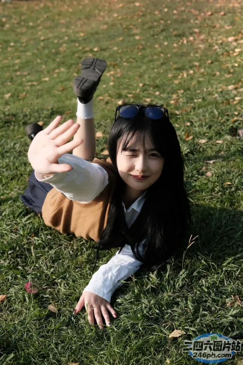 有个女人拿着一瓶水躺在草地上