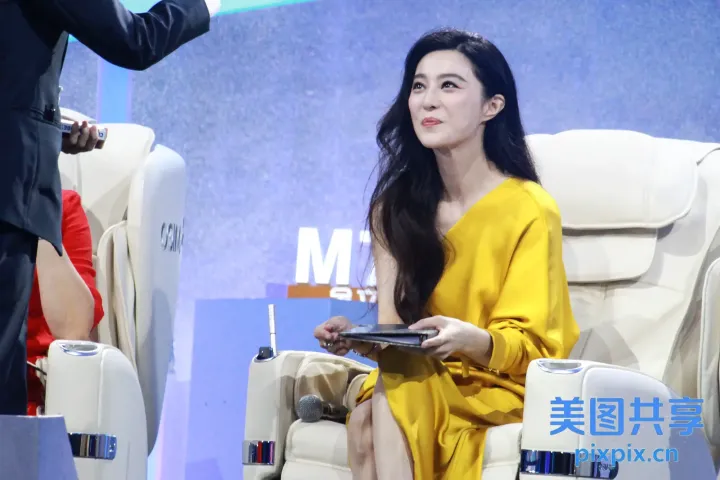 女士坐在椅子上，手里拿着平板电脑