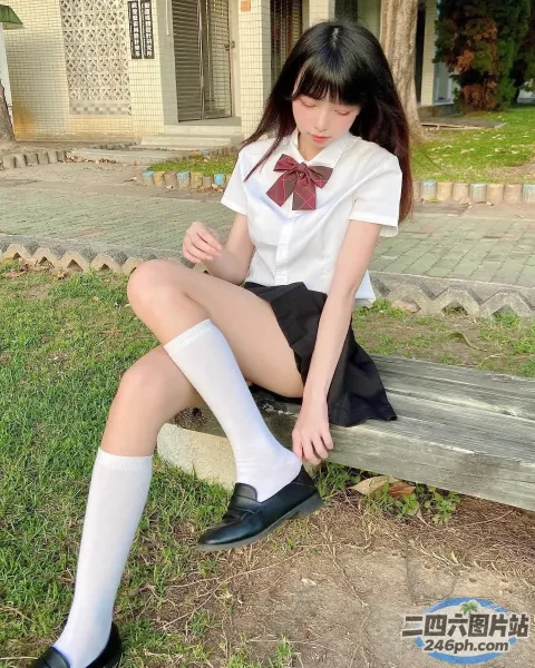 穿着校服坐在长凳上的 arafed 亚裔妇女