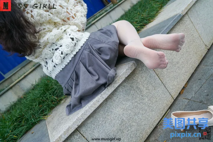 有一个女人坐在壁架上，双脚抬起