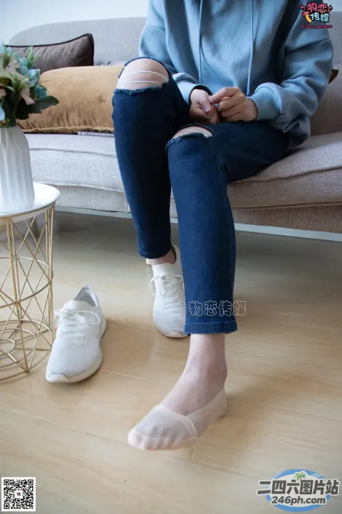 有人坐在沙发上，双脚撑着
