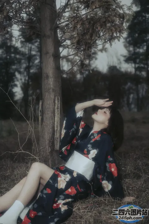 穿着和服坐在树下的 arafed 女人
