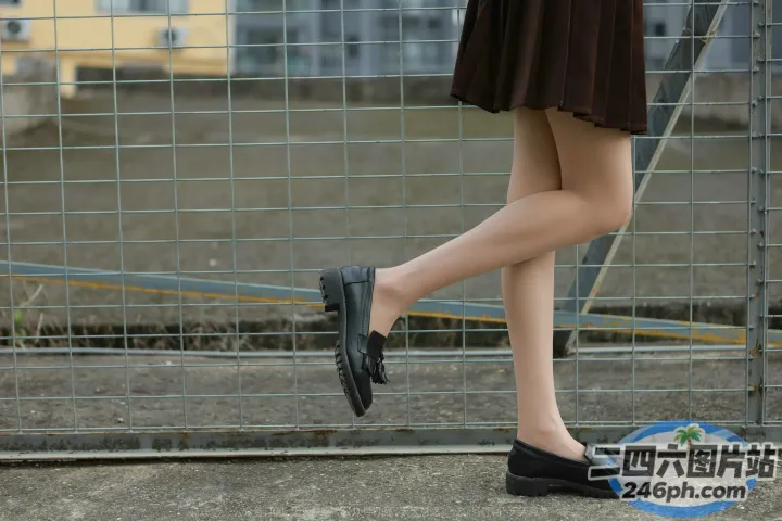 有个女人拿着手机走在人行道上