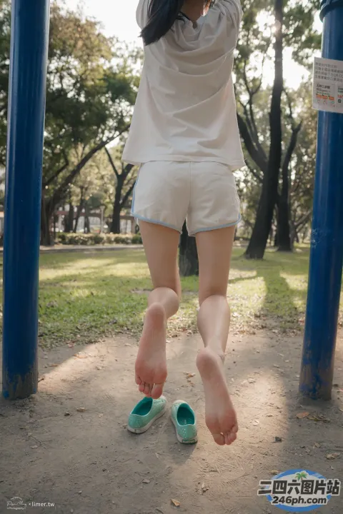身穿白衬衫和短裤的 Araffed 女子在蓝色杆子上跳跃