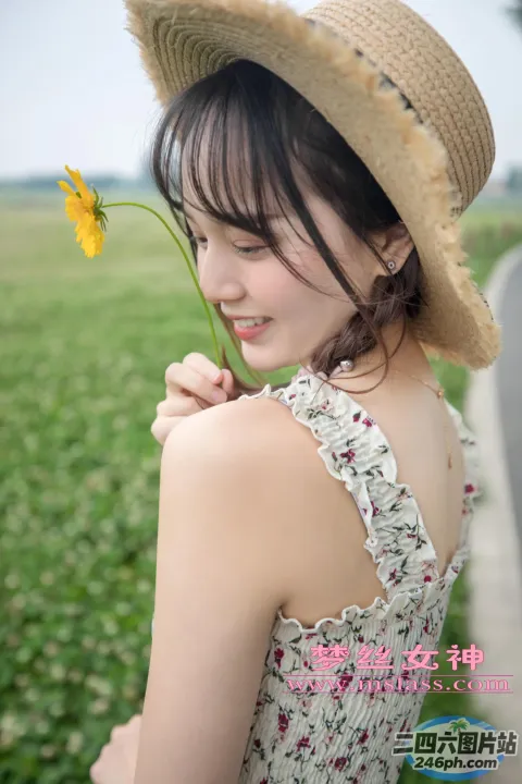 戴帽子的女人拿着一朵花的特写