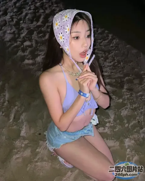 有一个女人戴着帽子坐在海滩上