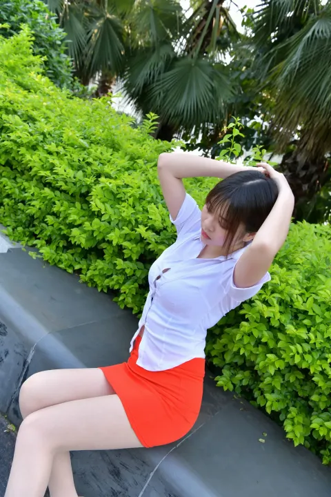 坐在公园长椅上的 arafed 亚裔女子